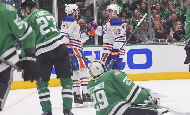 Edmonton Oilers center Ryan Nugent-Hopkins (93) celebrates his goal with teammate Connor McDavid (97) as Dallas Stars goaltender Jake Oettinger (29) and defenseman Esa Lindell (23) look on during the second period in Game 1 of the Western Conference finals in the NHL hockey Stanley Cup playoffs Wednesday, May 21, 2025, in Dallas. (AP Photo/LM Otero)