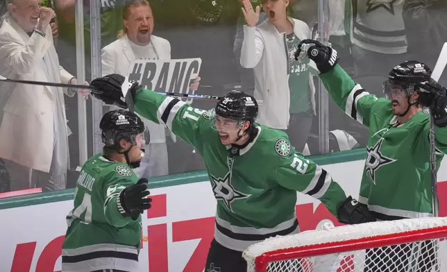 Dallas Stars center Mikael Granlund (64) celebrates a goal with teammates Jason Robertson (21) and Mason Marchment during the third period in Game 1 of the Western Conference finals in the NHL hockey Stanley Cup playoffs against the Edmonton Oilers, Wednesday, May 21, 2025, in Dallas. (AP Photo/LM Otero)