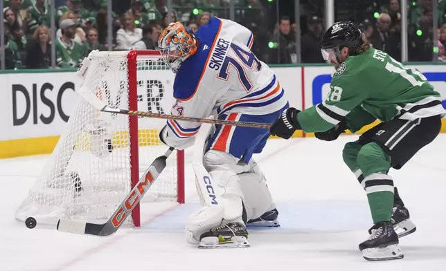 Edmonton Oilers goaltender Stuart Skinner (74) clears the goal against Dallas Stars center Sam Steel (18) during the first period in Game 1 of the Western Conference finals in the NHL hockey Stanley Cup playoffs Wednesday, May 21, 2025, in Dallas. (AP Photo/LM Otero)