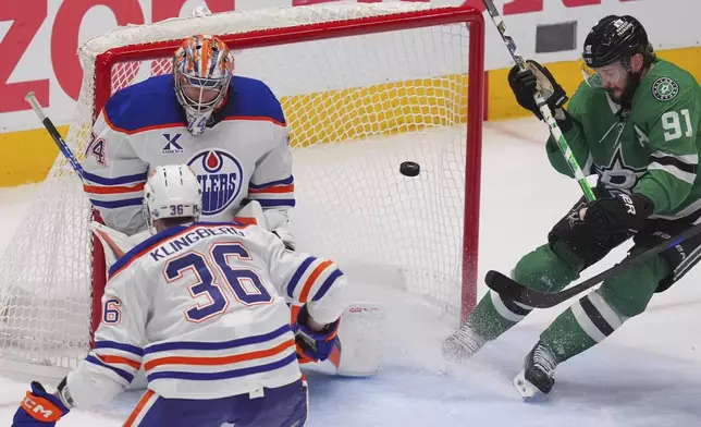 Edmonton Oilers goaltender Stuart Skinner (74) and defenseman John Klingberg (36) defend the goal against Dallas Stars center Tyler Seguin (91) during the third period in Game 1 of the Western Conference finals in the NHL hockey Stanley Cup playoffs Wednesday, May 21, 2025, in Dallas. (AP Photo/LM Otero)