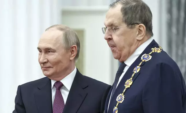 Russian President Vladimir Putin, left, awards Russian Foreign Minister Sergey Lavrov with the Order of St. Andrew the Apostle the First-Called during a ceremony to present highest state awards in the Catherine Hall of the Kremlin's Senate Palace in Moscow, Russia, Thursday, May 22, 2025. (Alexander Kazakov, Sputnik, Kremlin Pool Photo via AP)