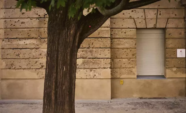 Eighty years after the end of World War II, holes from artillery fire are still visible on the facade of a house in the city center of Berlin, Germany, Friday, May 2, 2025. (AP Photo/Markus Schreiber)