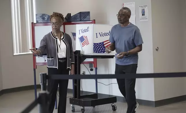 FILE - Joseph Clarkson Sr., 72, right, takes his ballot to a scanner during the South Carolina Democratic primary at a Richland County early voting site in Columbia, S.C., Jan. 26, 2024. (AP Photo/Serkan Gurbuz, File)