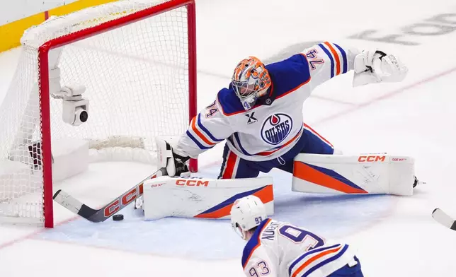 Edmonton Oilers goaltender Stuart Skinner makes a save against the Dallas Stars during the third period in Game 2 of the Western Conference finals in the NHL hockey Stanley Cup playoffs, Friday, May 23, 2025, in Dallas. (AP Photo/LM Otero)
