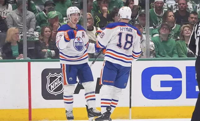 Edmonton Oilers center Ryan Nugent-Hopkins (93) celebrates after his goal with teammate Zach Hyman (18) during the first period in Game 2 of the Western Conference finals in the NHL hockey Stanley Cup playoffs against the Dallas Stars, Friday, May 23, 2025, in Dallas. (AP Photo/LM Otero)