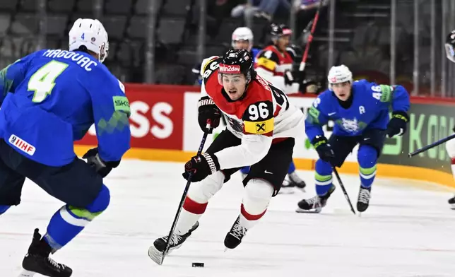 Austria's Marco Kasper, center, in action during the IIHF Ice Hockey World Championship group A match between Slovenia and Austria at Avicii Arena, in Stockholm, Sweden, Sunday, May 18, 2025. (Anders Wiklund/TT News Agency via AP)