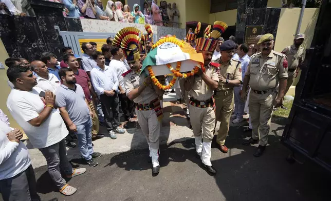 Police personnel carry the casket containing the body of Raj Thapa, a senior bureaucrat who was killed in Pakistani shelling in Rajouri, at his funeral in Jammu, India, Sunday, May 11, 2025. (AP Photo/Channi Anand)