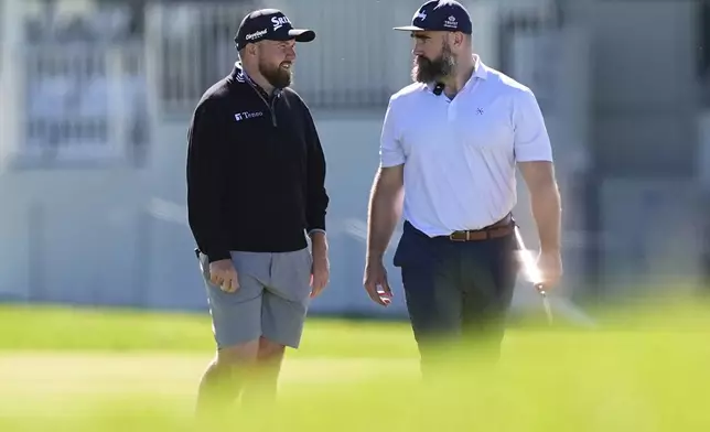 Former Philadelphia Eagles football player Jason Kelce, right, and Shane Lowry, of Ireland, talk on the 18th hole during a pro-am before the Truist Championship golf tournament at the Philadelphia Cricket Club, Wednesday, May 7, 2025, in Flourtown, Pa. (AP Photo/Matt Rourke)