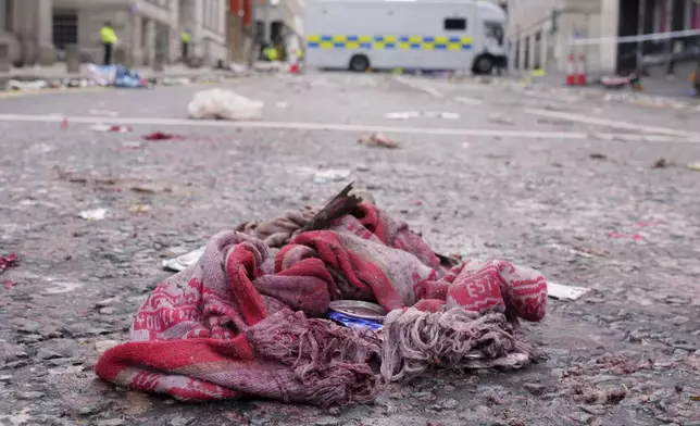 A fan scarf lies near the site where a 53-year-old British man plowed a minivan into a crowd of Liverpool soccer fans who were celebrating the city's Premier League championship Monday, injuring more than 45 people in Liverpool, England, Tuesday, May 27, 2025.(AP Photo/Jon Super)
