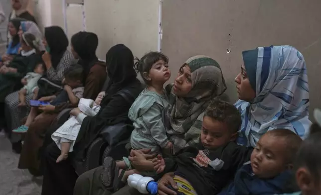 Palestinian women wait with their sick children for medical care in an overcrowded clinic in Gaza City, Wednesday, May 28, 2025. (AP Photo/Jehand Alshrafi)
