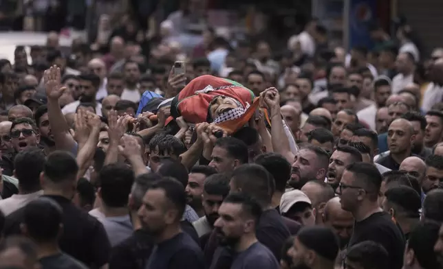 Palestinians carry the body of Mahmoud Al-Kharaz, 32, who was killed during an Israeli military raid, as they attend his funeral in the West Bank city of Nablus, Tuesday, May 27, 2025. (AP Photo/Majdi Mohammed)