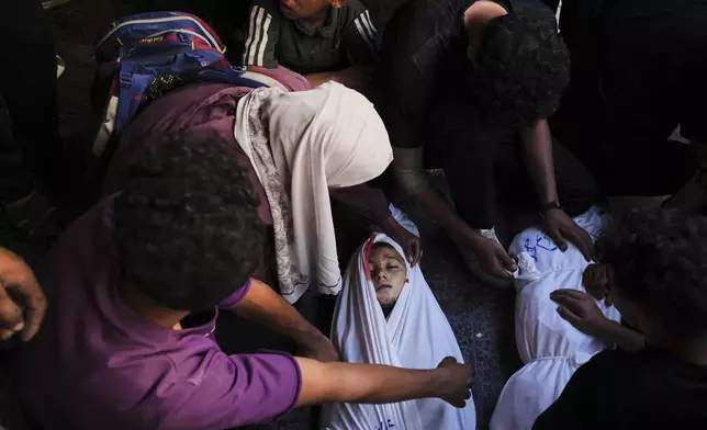 Mourners gather around the body of Palestinian child Ghazwane Hamdan,10, killed in an Israeli army airstrike, and brought to the Baptist Hospital in Gaza City, Monday, May 26, 2025. (AP Photo/Jehad Alshrafi)