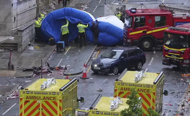 Police and emergency personnel deal with an incident after a car collided with pedestrians near the Liver Building during the Premier League winners parade in Liverpool, England, Monday, May 26, 2025.(AP Photo/Jon Super)