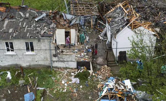 People clear the rubble of residential houses destroyed by a Russian strike in Korostyshiv, Zhytomyr region, Ukraine, Sunday, May 25, 2025. (AP Photo/Evgeniy Maloletka)