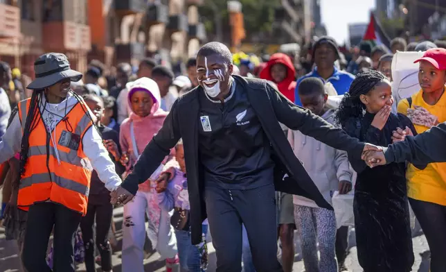 People participate in the annual Hillbrow street parade organized by the Windybrow Arts Centre and other local organisations in downtown Johannesburg, South Africa, Saturday, May 24, 2025. (AP Photo/Jerome Delay)
