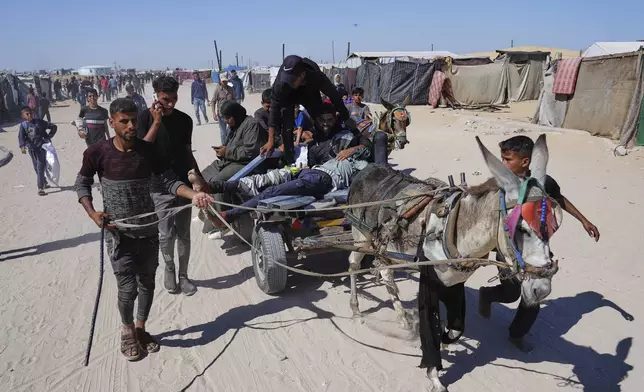 Palestinians carry an injured man after he was shot at an aid distribution center run by the Gaza Humanitarian Foundation a U.S.-backed organization approved by Israel in Khan Younis, southern Gaza Strip, on Thursday, May 29, 2025. (AP Photo/Abdel Kareem Hana)