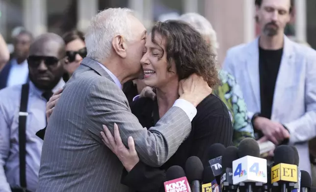 Attorney Mark Geragos, left, hugs Anamaria Baralt, cousin of Erik and Lyle Menendez, after the brothers' resentencing hearing Tuesday, May 13, 2025, in Los Angeles. (AP Photo/Damian Dovarganes)