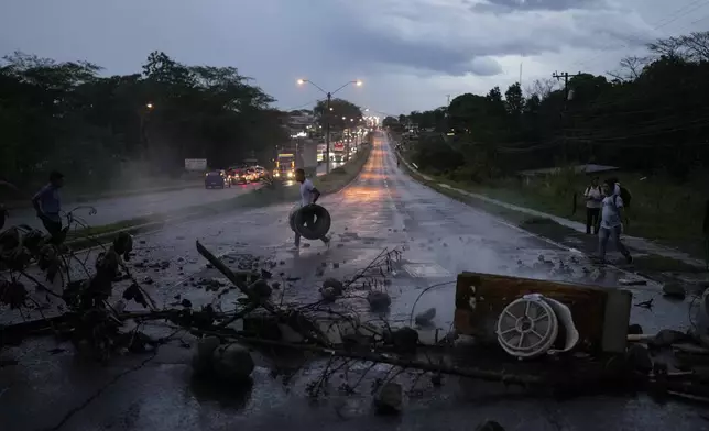 Anti-government demonstrators block a highway to protest a law, which overhauls the social security agency, and the recently signed Panama-U.S. memorandum concerning the Panama Canal, in Santiago, Panama, Tuesday, May 13, 2025. (AP Photo/Matias Delacroix)