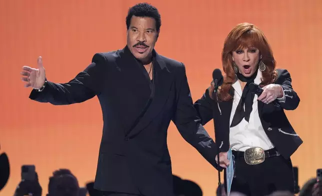 Host Reba McEntire, right, introduces Lionel Richie during the 60th annual Academy of Country Music Awards on Thursday, May 8, 2025, in Frisco, Texas. (AP Photo/Chris Pizzello)