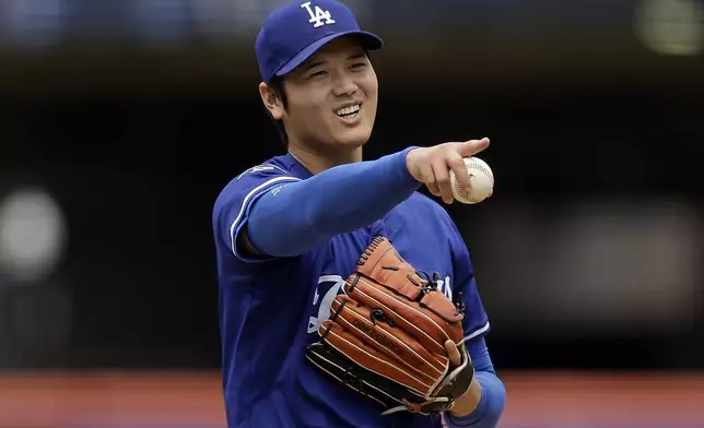 Los Angeles Dodgers' Shohei Ohtani (17), of Japan, reacts while throwing live batting practice before a baseball game against the New York Mets on Sunday, May 25, 2025, in New York. (AP Photo/Adam Hunger)