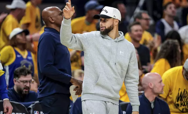 Golden State Warriors' Stephen Curry, center right, gestures to teammate Draymond Green that he is subbing in the first half of Game 3 of an NBA basketball second-round playoff series against the Minnesota Timberwolves in San Francisco, Saturday, May 10, 2025. (Carlos Avila Gonzalez/San Francisco Chronicle via AP)