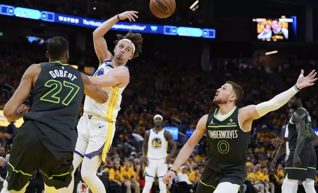 Golden State Warriors guard Brandin Podziemski, second from left, passes the ball between Minnesota Timberwolves center Rudy Gobert (27) and guard Donte DiVincenzo (0) during the first half of Game 3 of an NBA basketball second-round playoff series Saturday, May 10, 2025, in San Francisco. (AP Photo/Godofredo A. Vásquez)