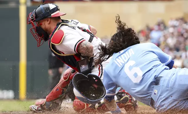 Kansas City Royals' Jonathan India scores on a double hit by Vinnie Pasquantino as Minnesota Twins catcher Christian Vázquez fields the ball during the fifth inning of baseball game Saturday, May 24, 2025, in Minneapolis. (AP Photo/Matt Krohn)