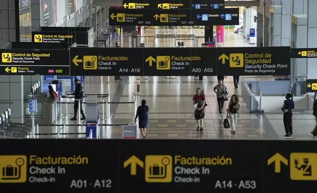 Travelers walk through Tocumen International Airport in Panama City, Thursday, May 22, 2025, as Panama and Venezuela prepare to resume commercial flights nearly a year after suspending them when Panamanian President Jose Raul Mulino refused to recognize the re-election of Venezuelan President Nicolas Maduro. (AP Photo/Matias Delacroix)