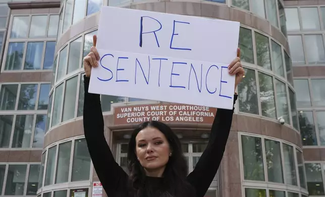 Natasha Blasick holds a sign in support of Erik and Lyle Menendez outside the Van Nuys Courthouse during a hearing in the brothers' case Tuesday, May 13, 2025, in Los Angeles. (AP Photo/Damian Dovarganes)