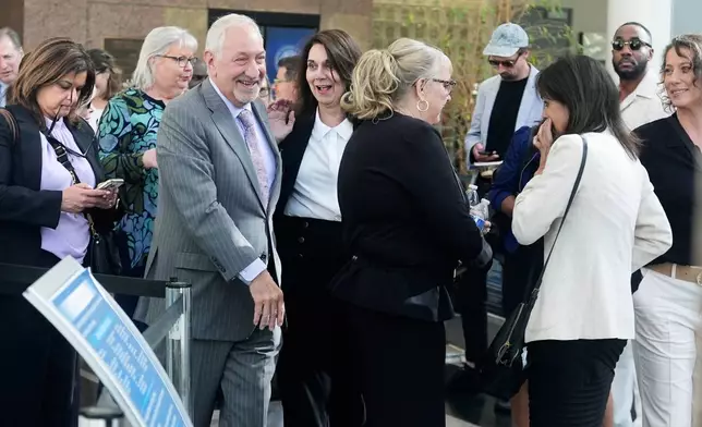 Attorney Mark Geragos, left, with family and supporters of Erik and Lyle Menendez, smiles as he leaves the courthouse after the brothers' resentencing hearing Tuesday, May 13, 2025, in Los Angeles. (AP Photo/Damian Dovarganes)