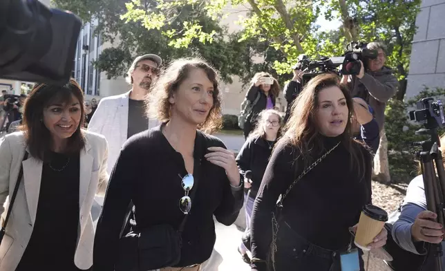 Anamaria Baralt, center, and other family and supporters of Erik and Lyle Menendez arrive at court for a hearing in the brothers' case Tuesday, May 13, 2025, in Los Angeles. (AP Photo/Damian Dovarganes)