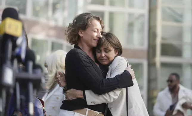 Anamaria Baralt, left, cousin of Erik and Lyle Menendez, left, gets a hug as she leaves the courthouse after the brothers' resentencing hearing Tuesday, May 13, 2025, in Los Angeles. (AP Photo/Damian Dovarganes)