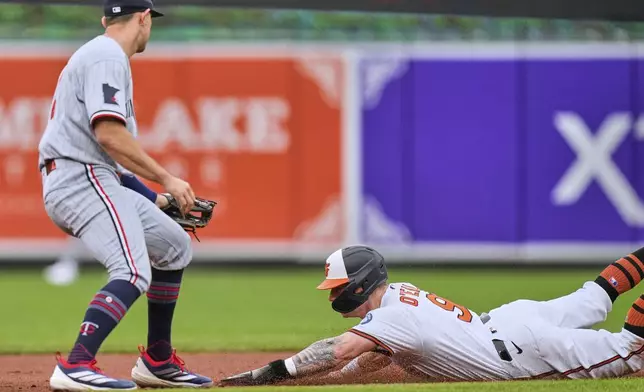 Baltimore Orioles' Tyler O'Neill (9) steals second base in front of Minnesota Twins second baseman Brooks Lee (2) during the fourth inning in the first baseball game of a doubleheader, Wednesday, May 14, 2025, in Baltimore. (AP Photo/Stephanie Scarbrough)