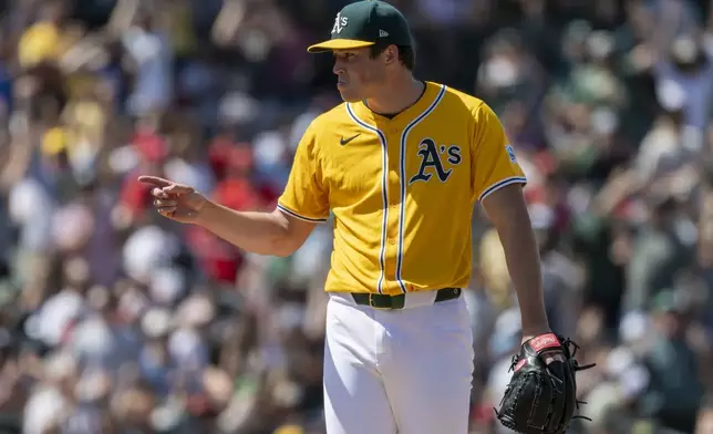 Athletics pitcher Mason Miller points to catcher Willie MacIver after winning a baseball game against the Philadelphia Phillies, Sunday, May 25, 2025, in West Sacramento, Calif. (AP Photo/Sara Nevis)