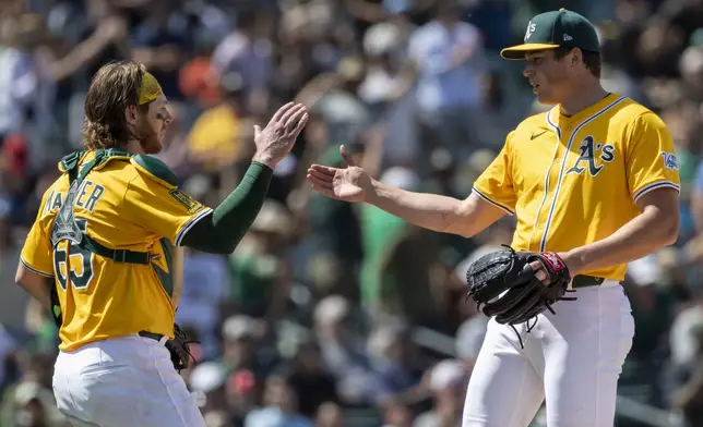 Athletics catcher Willie MacIver, left, high-fives pitcher Mason Miller, right, after winning a baseball game against the Philadelphia Phillies, Sunday, May 25, 2025, in West Sacramento, Calif. (AP Photo/Sara Nevis)