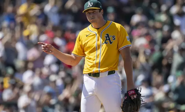 Athletics pitcher Mason Miller points to catcher Willie MacIver after winning a baseball game against the Philadelphia Phillies, Sunday, May 25, 2025, in West Sacramento, Calif. (AP Photo/Sara Nevis)