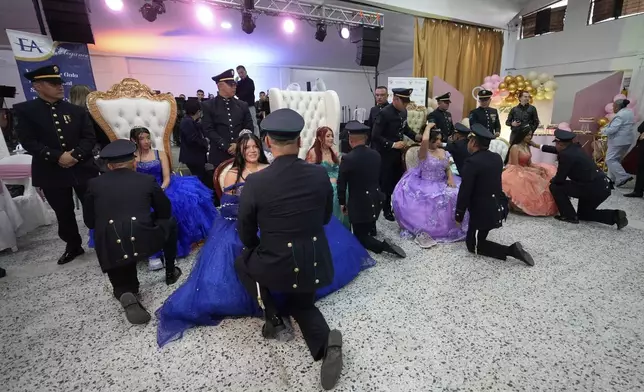 Police officers prepare to dance a waltz with their designated quinceañera at a group celebration, in Bogota, Colombia, Friday, May 2, 2025. The Sueños Hechos Foundation, led by a former police officer, is hosting a quinceañera celebration on Friday for 24 disadvantaged teen girls. (AP Photo/Fernando Vergara)