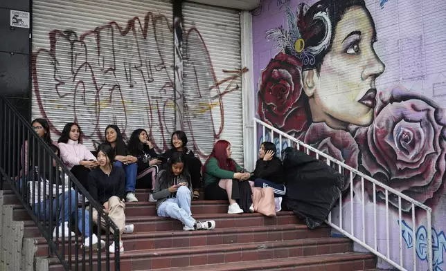 Quinceañeras wait outside a beauty salon where they will have their hair styled and makeup done for free, in Bogota, Colombia, Friday, May 2, 2025. The Sueños Hechos Foundation, led by a former police officer, is hosting a quinceañera celebration on Friday for 24 disadvantaged teen girls. (AP Photo/Fernando Vergara)