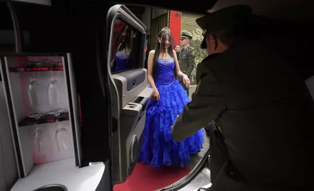 A quinceañera prepares to get into a limousine to be driven to a quinceañera celebration, in Bogota, Colombia, Friday, May 2, 2025. The Sueños Hechos Foundation, led by a former police officer, is hosting a quinceañera celebration on Friday for 24 disadvantaged teen girls. (AP Photo/Fernando Vergara)
