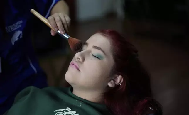 Quinceañera Gabriela Moncada has her makeup done for free, in Bogota, Colombia, Friday, May 2, 2025. The Sueños Hechos Foundation, led by a former police officer, is hosting a quinceañera celebration on Friday for 24 disadvantaged teen girls. (AP Photo/Fernando Vergara)