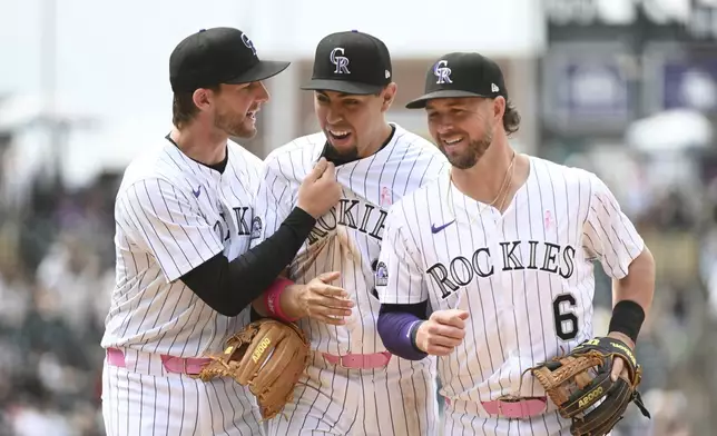 From left to right, Colorado Rockies third baseman Ryan McMahon, shortstop Alan Trejo and second baseman Kyle Farmer celebrate after a double play in the seventh inning of a baseball game against the San Diego Padres, Sunday, May 11, 2025, in Denver. (AP Photo/Geneva Heffernan)