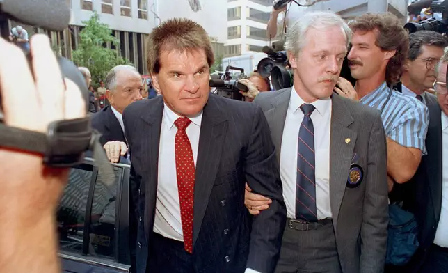 FILE - Former Cincinnati Reds manager Pete Rose is escorted by a Federal Marshal, right, as he arrives at federal court in Cincinnati, Ohio on July 19, 1990. (AP Photo/Mark Lyons, File)
