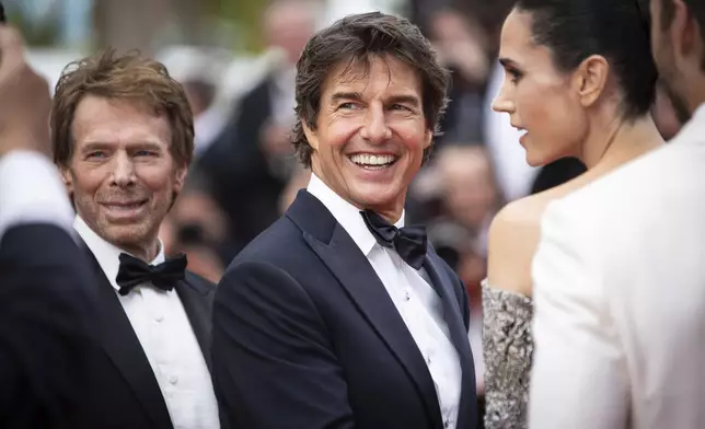 FILE - Tom Cruise, center, appears with co-star Jennifer Connelly, right, and producer Jerry Bruckheimer at the premiere of the film 'Top Gun: Maverick" at the 75th international film festival, in Cannes, southern France, on May 18, 2022. (Photo by Vianney Le Caer/Invision/AP, File)