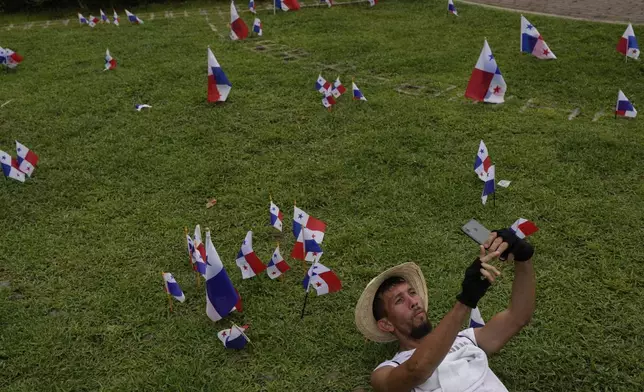 A man takes a selfie during a protest against the government's decision to sign a memorandum of understanding on security cooperation with the U.S. that protesters believe violates their nation's sovereignty in Panama City, Tuesday, May 6, 2025. (AP Photo/Matias Delacroix)