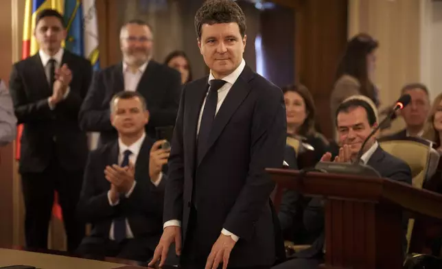 Romanian President elect Nicusor Dan, front center, stands at the Constitutional Court during the ceremony for validation of his presidential mandate, after winning the country's presidential election redo in Bucharest, Romania, Thursday, May 22, 2025. (AP Photo/Vadim Ghirda)