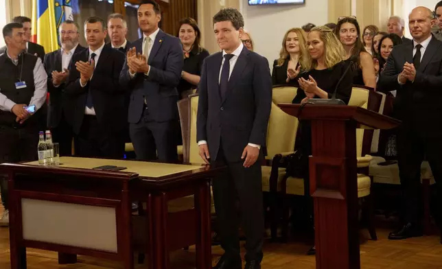 Romanian President elect Nicusor Dan, front center, stands at the Constitutional Court during the ceremony for validation of his presidential mandate, after winning the country's presidential election redo in Bucharest, Romania, Thursday, May 22, 2025. (AP Photo/Vadim Ghirda)