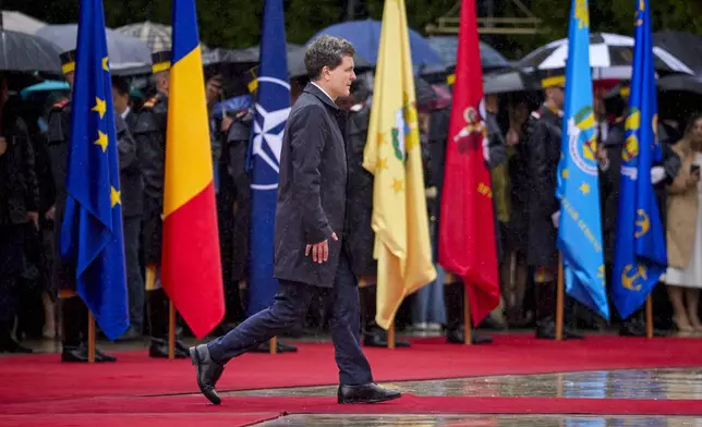 Romania's newly elected president Nicusor Dan reviews the honour guard during a welcoming ceremony at the Cotroceni Presidential Palace, after being sworn in at the parliament, in Bucharest, Romania, Monday, May 26, 2025. (AP Photo/Andreea Alexandru)