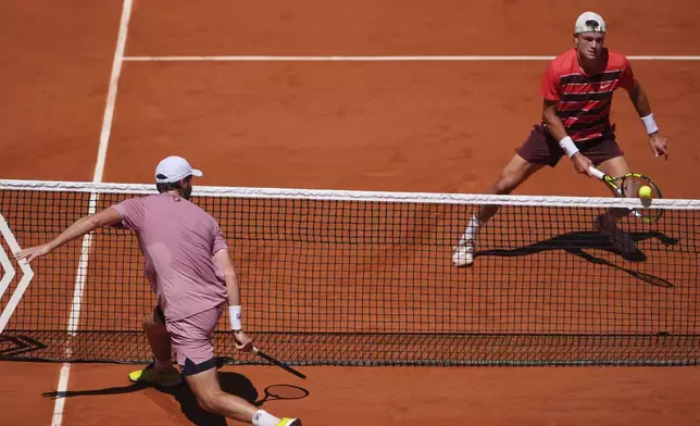 Denmark's Holger Rune, right, plays a volley to France's Quentin Halys during their third round match of the French Tennis Open, at the Roland-Garros stadium, in Paris, Friday, May 30, 2025. (AP Photo/Lindsey Wasson)