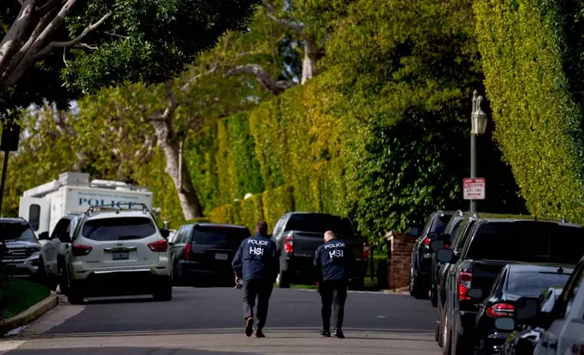 FILE - Law enforcement personnel walk on a street near after federal law enforcement executed a raid at a property belonging to Sean "Diddy" Combs on March 25, 2024, in Los Angeles. (AP Photo/Eric Thayer, File)