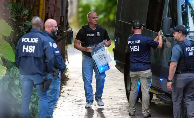 FILE - A law enforcement agent carries a bag of evidence to a van as federal agents stand at the entrance to a property belonging to rapper Sean "Diddy" Combs, on March 25, 2024, on Star Island in Miami Beach, Fla. (AP Photo/Rebecca Blackwell, File)